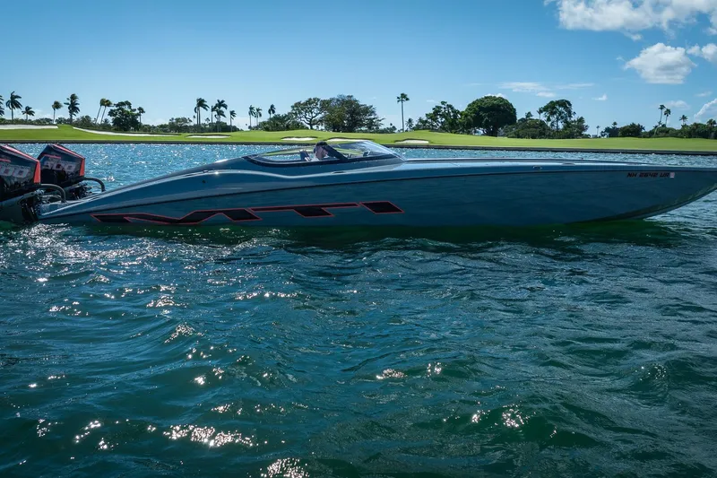  Yacht Photos Pics 2024 MTI 390X speedboat on water, sunny day, palm trees in background.