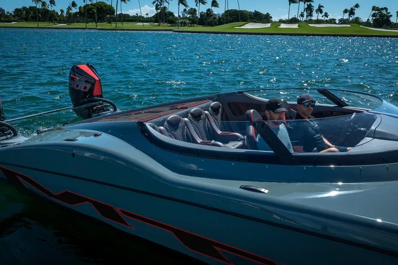  Yacht Photos Pics 2024 MTI 390X speedboat cruising on a sunny day with two passengers.