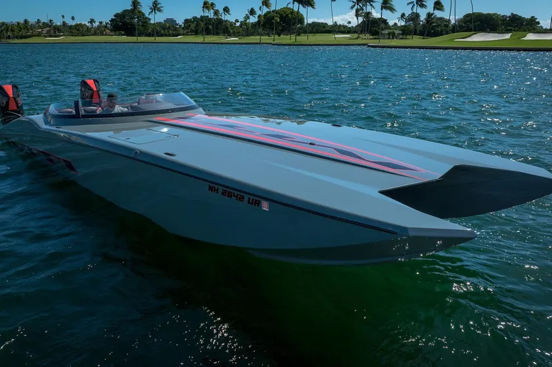  Yacht Photos Pics 2024 MTI 390X powerboat cruising on a sunny lake with palm trees in the background.