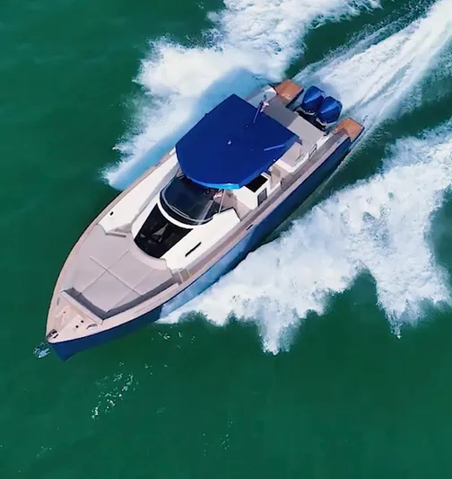 Mine Yacht Photos Pics 2022 Tesoro T38 Outboard cruising on turquoise waters, aerial view.