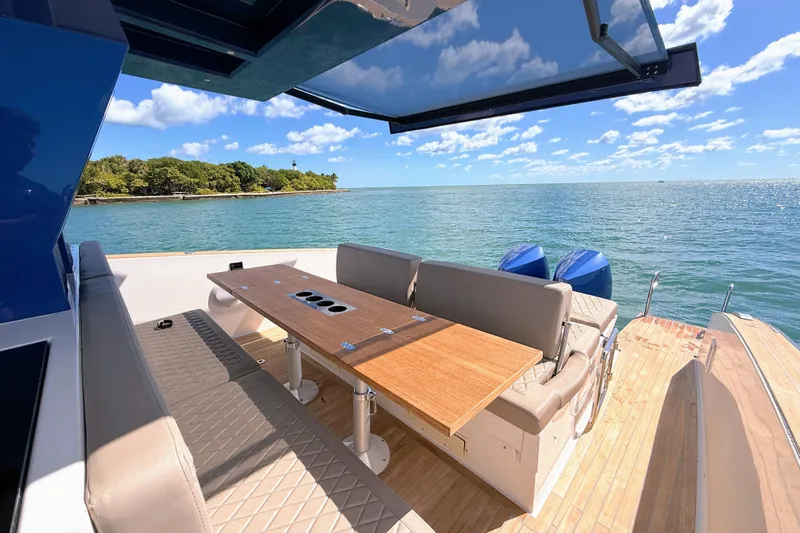 Mine Yacht Photos Pics 2022 Tesoro T38 Outboard boat with seating area, table, and ocean view.