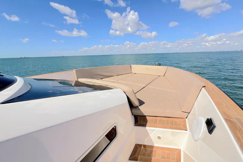 Mine Yacht Photos Pics 2022 Tesoro T38 Outboard boat with spacious deck, cruising on calm blue waters.