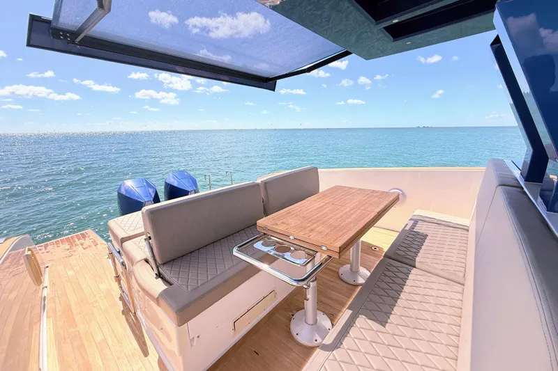 Mine Yacht Photos Pics 2022 Tesoro T38 Outboard boat interior with seating and table, overlooking the ocean.