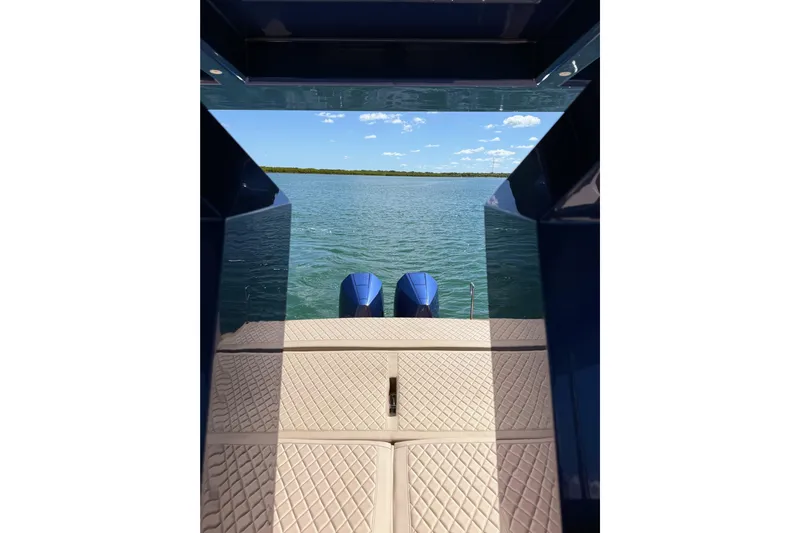 Mine Yacht Photos Pics 2022 Tesoro T38 Outboard boat with dual engines on a calm lake.