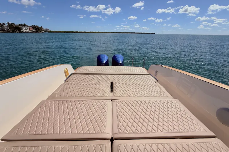 Mine Yacht Photos Pics 2022 Tesoro T38 Outboard boat with cushioned deck, ocean view, and clear sky.