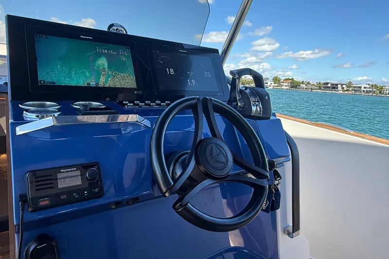 Mine Yacht Photos Pics 2022 Tesoro T38 Outboard boat dashboard with navigation screens and steering wheel.