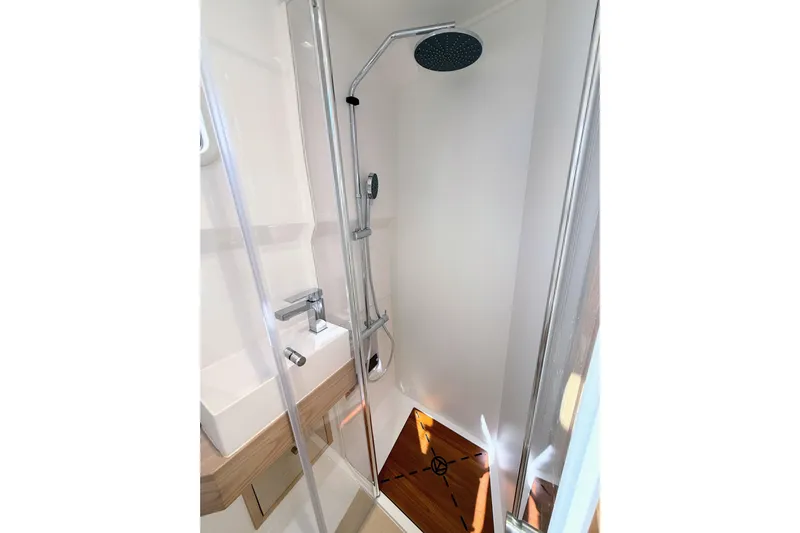 Mine Yacht Photos Pics Modern shower area in 2022 Tesoro T38 Outboard boat, featuring sleek fixtures and wooden flooring.