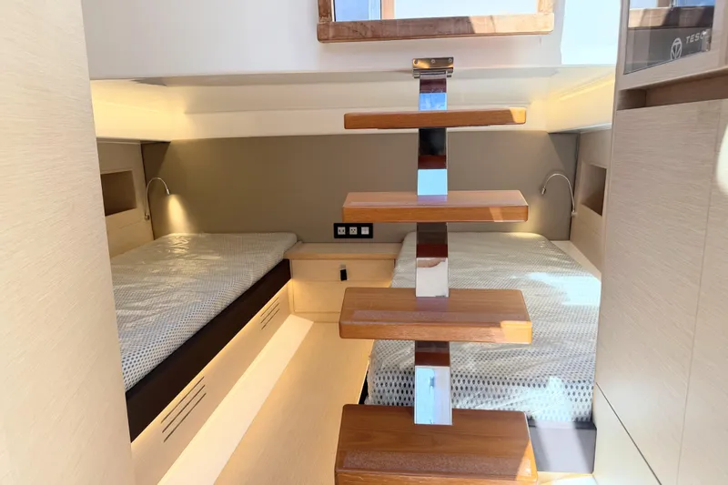 Mine Yacht Photos Pics 2022 Tesoro T38 Outboard cabin interior with twin beds and wooden steps.