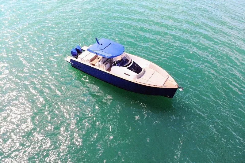 Mine Yacht Photos Pics 2022 Tesoro T38 Outboard boat on clear turquoise water, aerial view.