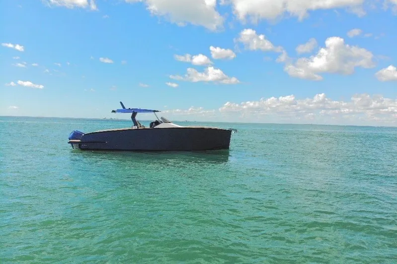 Mine Yacht Photos Pics 2022 Tesoro T38 Outboard boat on calm sea under blue sky with clouds.