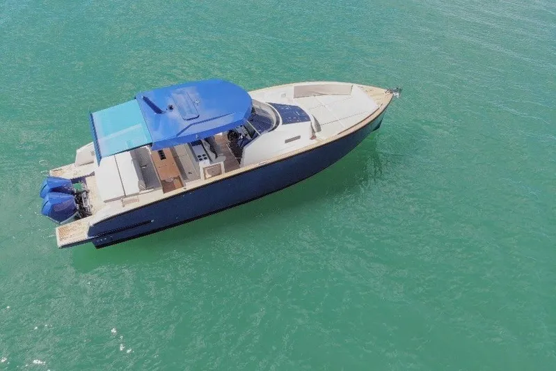 Mine Yacht Photos Pics 2022 Tesoro T38 Outboard boat on clear turquoise water, aerial view.