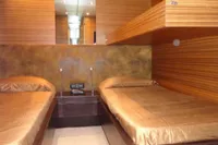 Luxurious Tecnomar 100 yacht cabin with twin beds, wood paneling, and modern design, 2009 model.