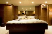 Luxurious bedroom interior on 2009 Tecnomar 100 yacht, featuring modern design and ambient lighting.