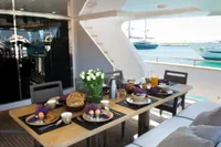 Luxury yacht dining setup on Tecnomar 100, 2009, with elegant breakfast spread and ocean view.