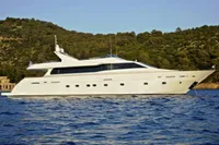 Luxurious 2009 Tecnomar 100 yacht cruising on serene waters near a lush coastline.