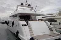 Luxury Tecnomar 100 yacht, 2009 model, docked at marina under cloudy skies.
