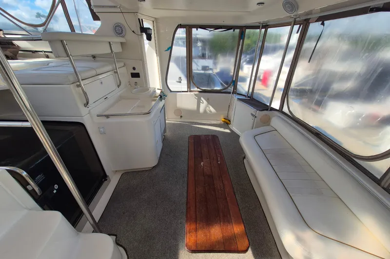 Funny Cide Yacht Photos Pics 1999 Sea Ray 420 Aft Cabin interior with seating and wooden table.