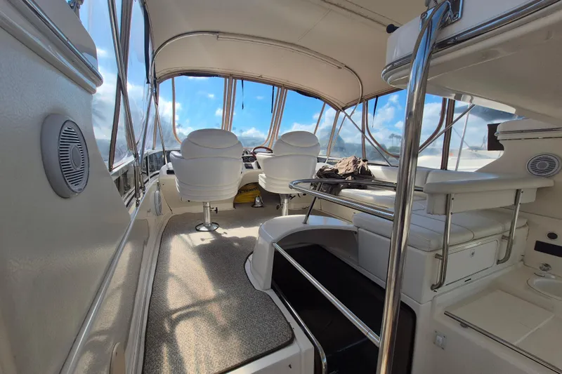 Funny Cide Yacht Photos Pics 1999 Sea Ray 420 Aft Cabin interior with helm, seating, and panoramic windows.