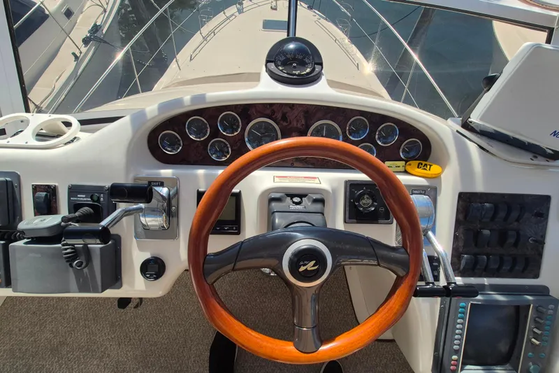 Funny Cide Yacht Photos Pics 1999 Sea Ray 420 Aft Cabin helm with wooden steering wheel and instrument panel.