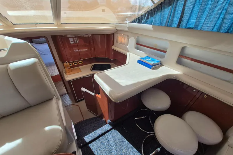 Funny Cide Yacht Photos Pics 1999 Sea Ray 420 Aft Cabin interior with seating, table, and kitchenette.