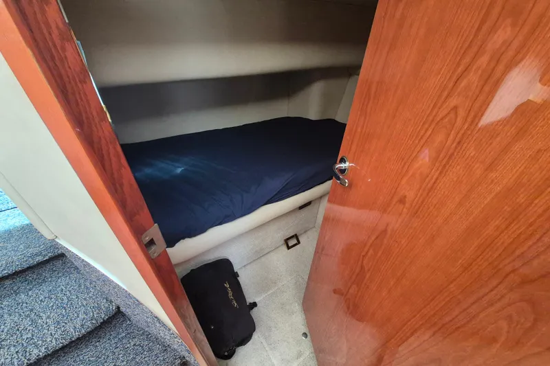 Funny Cide Yacht Photos Pics 1999 Sea Ray 420 Aft Cabin interior with cozy bed and wooden door.
