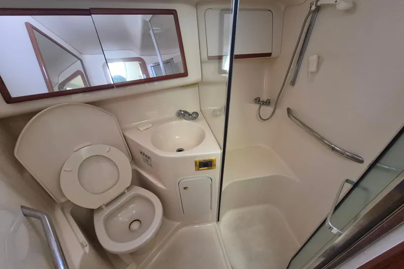 Funny Cide Yacht Photos Pics 1999 Sea Ray 420 Aft Cabin bathroom with toilet, sink, and shower area.