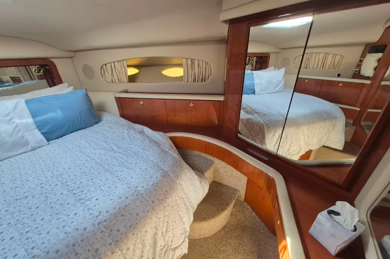Funny Cide Yacht Photos Pics Luxurious 1999 Sea Ray 420 Aft Cabin bedroom with elegant wood finishes and cozy bedding.