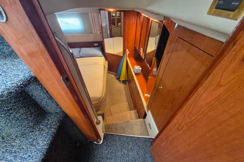 Funny Cide Yacht Photos Pics 1999 Sea Ray 420 Aft Cabin interior with wood paneling and cozy bedroom.