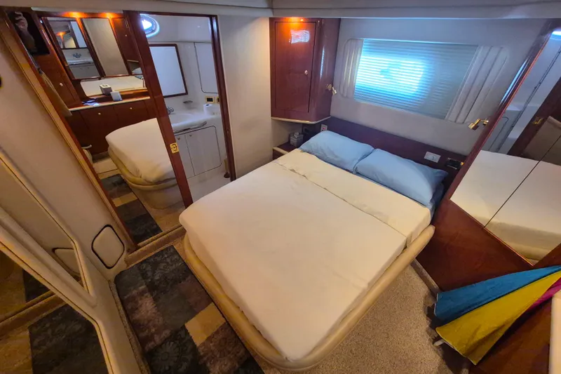 Funny Cide Yacht Photos Pics 1999 Sea Ray 420 Aft Cabin bedroom with cozy bed and elegant wood finishes.