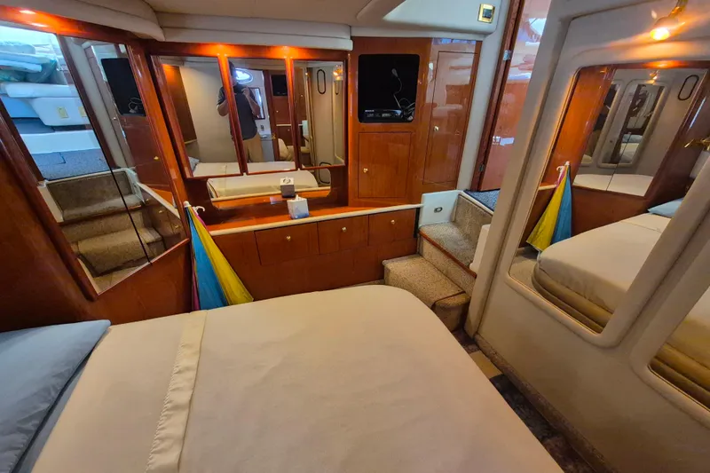 Funny Cide Yacht Photos Pics 1999 Sea Ray 420 Aft Cabin interior with wood cabinetry and cozy bedroom.