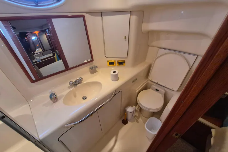 Funny Cide Yacht Photos Pics 1999 Sea Ray 420 Aft Cabin bathroom with sink, mirror, and toilet.