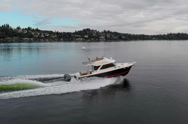  Yacht Photos Pics 2021 Cutwater C-32 CB cruising on a calm lake under cloudy skies.