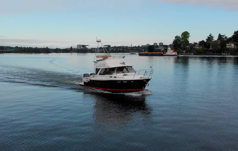  Yacht Photos Pics 2021 Cutwater C-32 CB cruising on a calm lake with scenic shoreline.