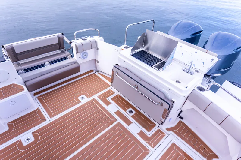  Yacht Photos Pics 2021 Cutwater C-32 CB boat deck with seating and grill, featuring teak-style flooring.
