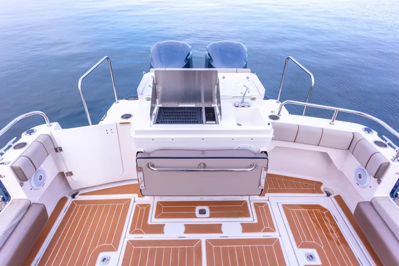  Yacht Photos Pics 2021 Cutwater C-32 CB boat deck with grill, seating, and twin engines on calm water.