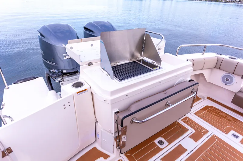  Yacht Photos Pics 2021 Cutwater C-32 CB boat with outdoor grill and twin engines on a calm lake.