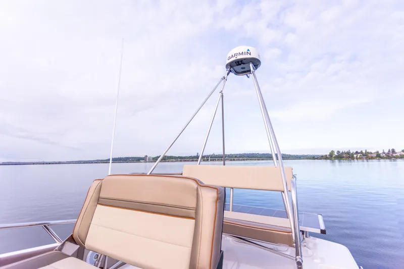  Yacht Photos Pics 2021 Cutwater C-32 CB boat with Garmin equipment on calm water under a cloudy sky.