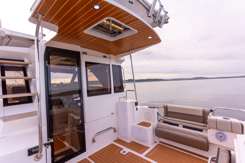 Yacht Photos Pics 2021 Cutwater C-32 CB boat interior with wood accents and seating, overlooking calm waters.