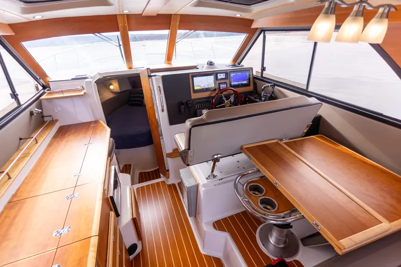  Yacht Photos Pics Interior of 2021 Cutwater C-32 CB boat with wood finishes and navigation equipment.