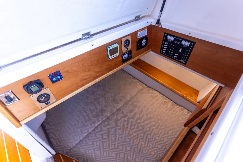  Yacht Photos Pics 2021 Cutwater C-32 CB cabin interior with control panel and cushioned sleeping area.