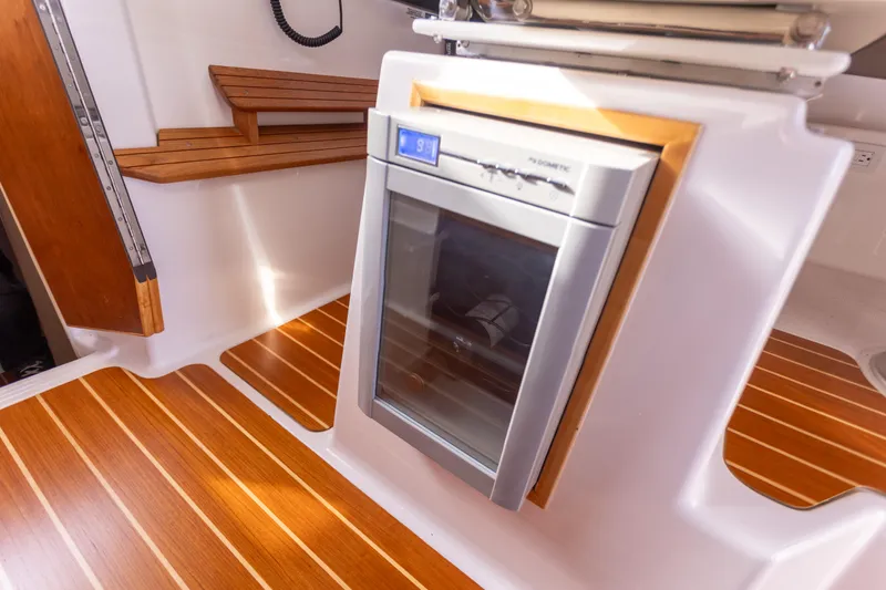  Yacht Photos Pics 2021 Cutwater C-32 CB interior with wood flooring and built-in refrigerator.