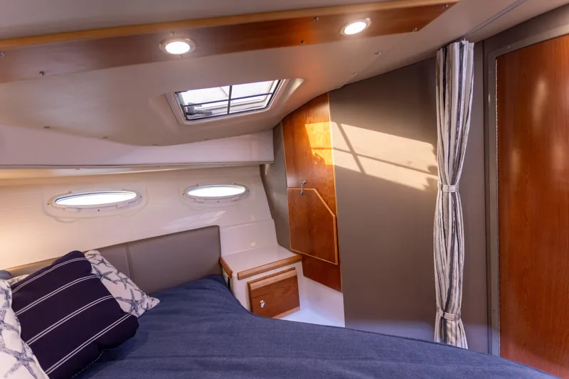  Yacht Photos Pics 2021 Cutwater C-32 CB cabin interior with bed, portholes, and skylight.