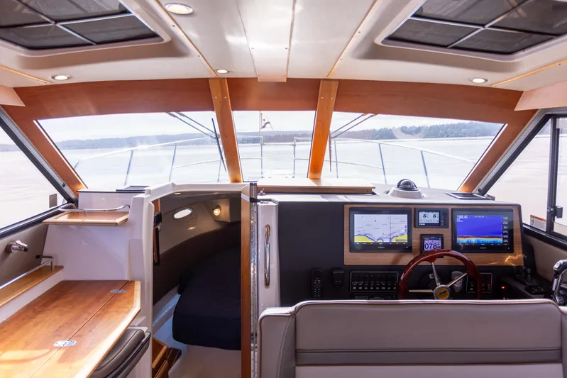  Yacht Photos Pics Interior of 2021 Cutwater C-32 CB boat with modern navigation equipment and wood accents.
