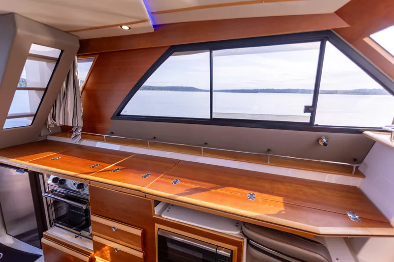  Yacht Photos Pics Interior of 2021 Cutwater C-32 CB yacht with sleek wooden cabinetry and large windows.