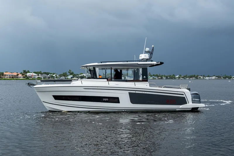  Yacht Photos Pics 2021 Jeanneau NC Sport 895 boat cruising on a calm lake under cloudy skies.