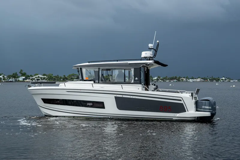  Yacht Photos Pics 2021 Jeanneau NC Sport 895 boat on calm water under cloudy sky.
