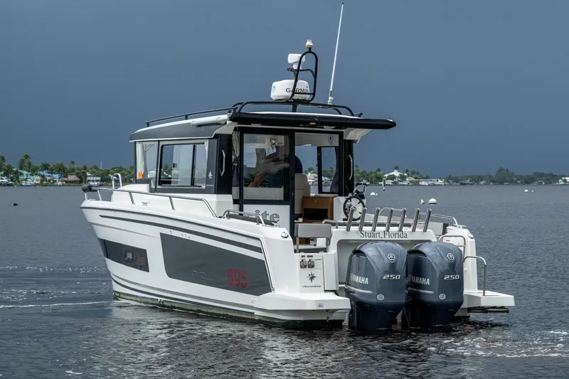 Yacht Photos Pics 2021 Jeanneau NC Sport 895 boat with dual Yamaha engines on a calm waterway.