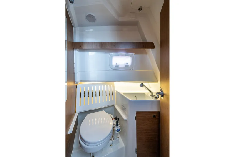  Yacht Photos Pics 2021 Jeanneau NC Sport 895 boat bathroom with toilet, sink, and window.