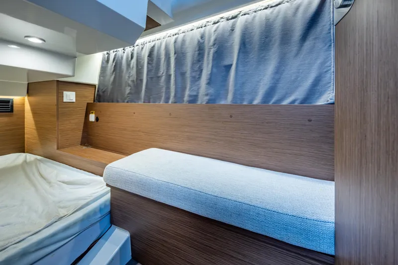  Yacht Photos Pics 2021 Jeanneau NC Sport 895 cabin interior with wood finish and cozy seating.