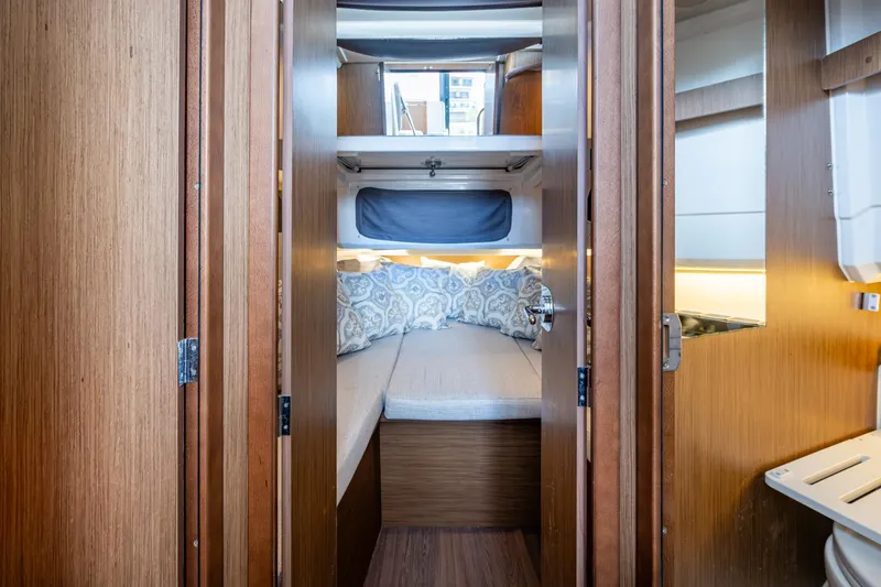  Yacht Photos Pics 2021 Jeanneau NC Sport 895 cabin interior with cozy bed and wooden finish.